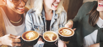 Alles über unseren Haferdrink Drei lachende Frauen mit je einer Tasse Kaffee mit Berief Hafergetränk.