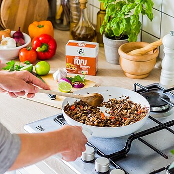 Packung Berief Tofu geräuchert neben Pfanne auf Kochstelle