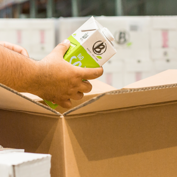 Symbolbild für den Shop: Jemand verpackt einen Getränkekarton von Berief