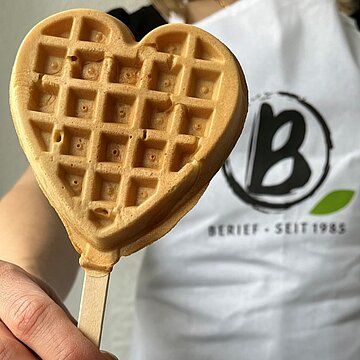 Berief beim Radio WAF Muttertag Eine herzförmige Waffel an einem Holzstiel wird ins Bild gehalten.