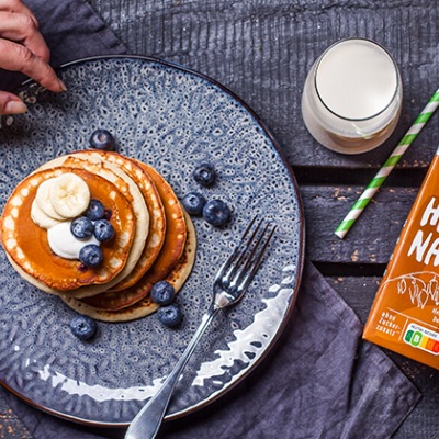 Pancakes auf einem blauen Teller ganiert mit Blaubeeren 