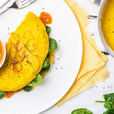 Zusammengeklapptes Omlett mit Füllung auf einem weißen Teller