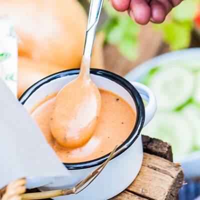 Dunkle Mayonnaise in einem kleinen Emaille-Topf mit Dekoration