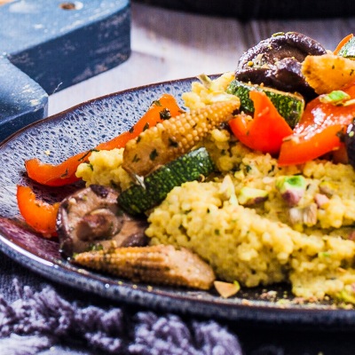 Couscous mit Gemüse auf einem blauen Teller