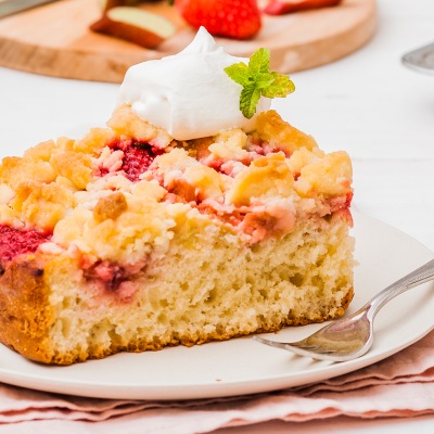 Streusselkuchen mit einem Klecks Sahne auf einem weißen Teller