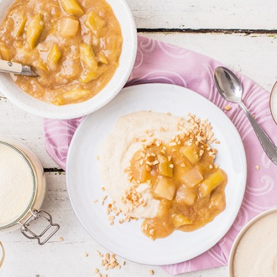 Veganer Grießpudding mit Rhabarber-Honigmelonen_Kompott Grießpudding auf einem weißen Tisch auf weißen Tellern mit Dekoration