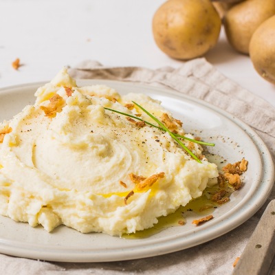Kartoffelpüree mit Kräuter-Topping auf einem weißen Teller
