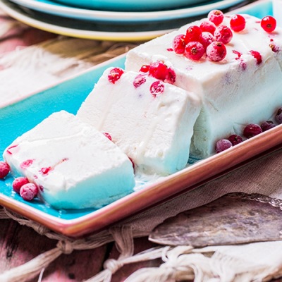 Weißes Dessert auf einer länglichen Schale mit Früchtetopping auf einem Tisch