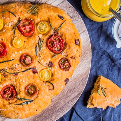 Fladenbrot gebacken mit Tomaten und Rosmarin auf einem Teller