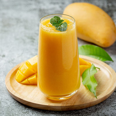 Mango-Lassi auf einem Holzteller mit Dekoration