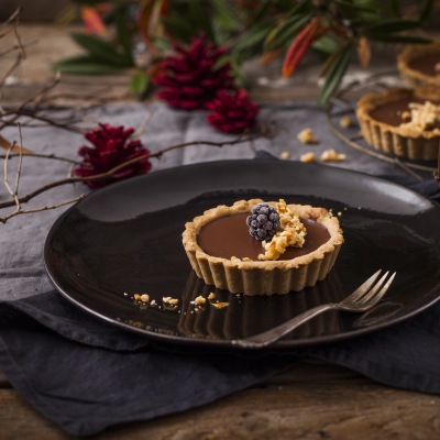Kleine Tortenböden mit Schokoladencreme und winterlicher Dekoration.