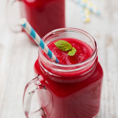 Rotes Getränk in einem Glas mit Strohhalm